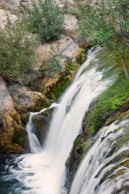 Top view of a small waterfall on a river in summer.