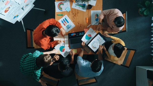 Top view of smart team working together while talking about chart Convocation