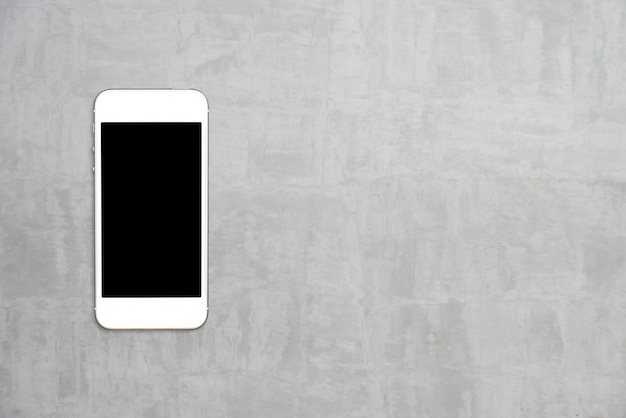 トップビュースマートフォンは、copyspaceとセメントのテーブルに黒い画面テンプレートをモックアップ。
