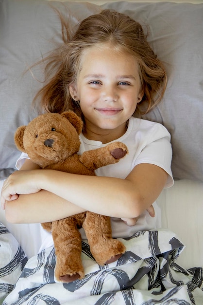 Photo top view of a smiling little girl lying on her back