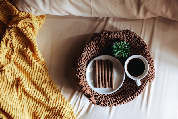 Top view of snack and a cup of coffee for breakfast on the bed