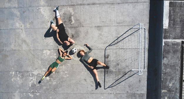 写真 トップビューのサッカーボールと友達は、練習後に一緒に屋上でリラックスします。