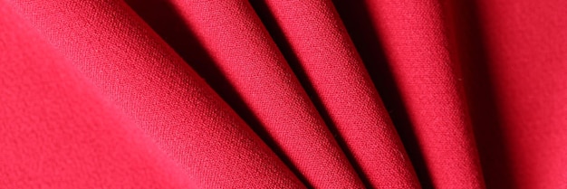 Top view of soft folded bright red textile material textured background natural ruby fabric
