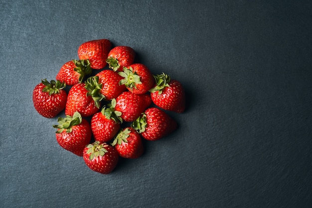 Top view of some red strawberries on dark