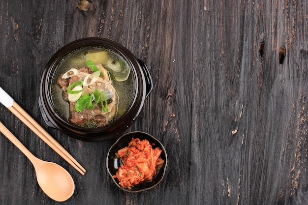 Photo top view sop buntut korea or korean sokkori gori gomtang, served with kimchi. copy space for text