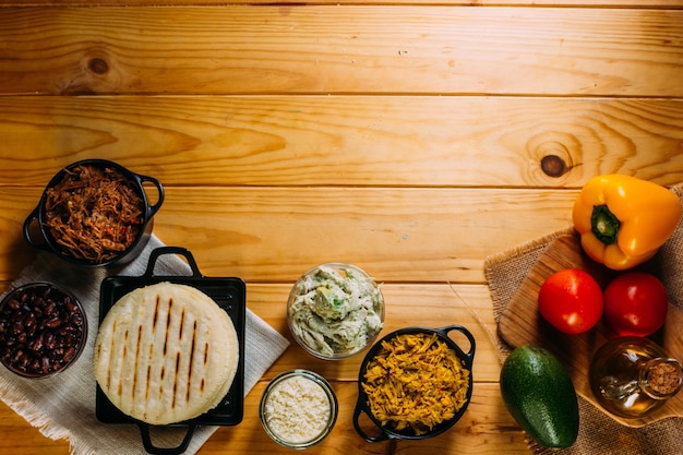 Top view of South American food called arepa and different ingredients