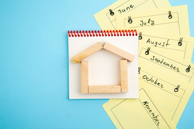 Photo top view spiral notebook wood blocks monthly reminder cards on blue background free space