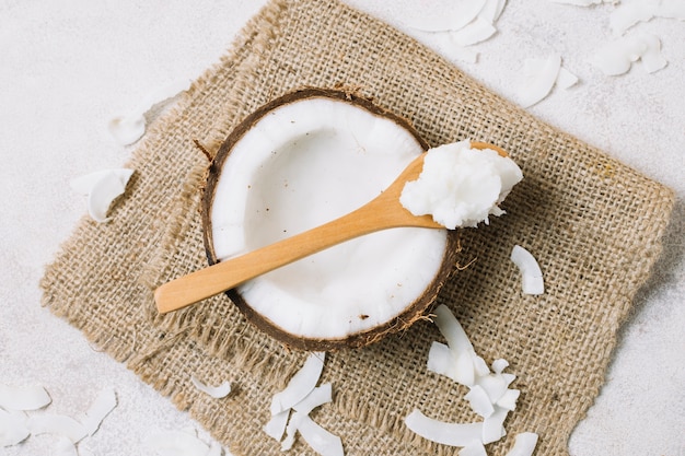 Top view spoonfull of coconut oil with coconut nut