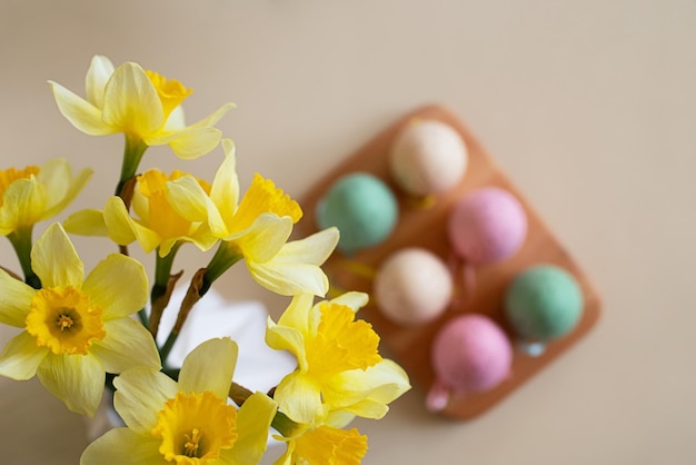 Top view of spring flowers with easter eggs on background