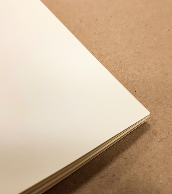 Top view of a stack of white paper on a brown background