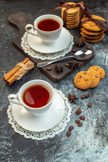 Top view of stacked cookies cinnamon limes on wooden cutting board and nude towel tea on ice background