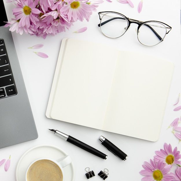 Photo top view stationary arrangement on desk with empty notebook