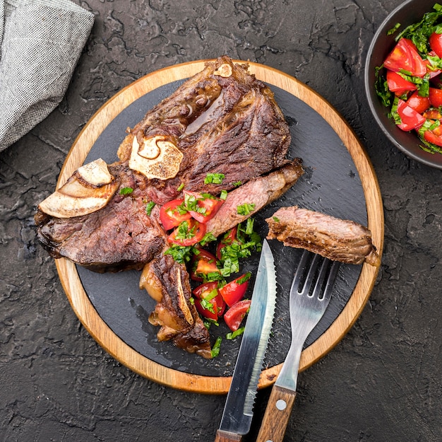 Top view of steak with cutlery and salad