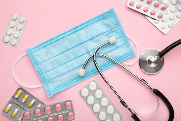 top view stethoscope, disposable face masks, and pills