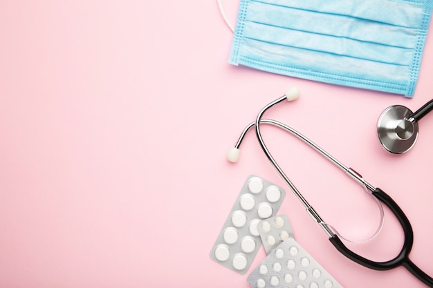 top view stethoscope, disposable face masks, and pills