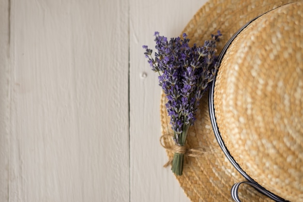 La vista dall'alto sul cappello di paglia è un grazioso bouquet di lavanda verde oliva. erba secca. vista dall'alto