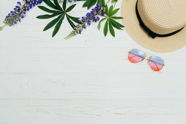 top view, straw hat, sunglasses and flowers on a white background