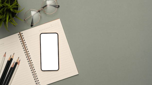 Top view Study table workspace with stationery smartphone mockup and copy space on grey background