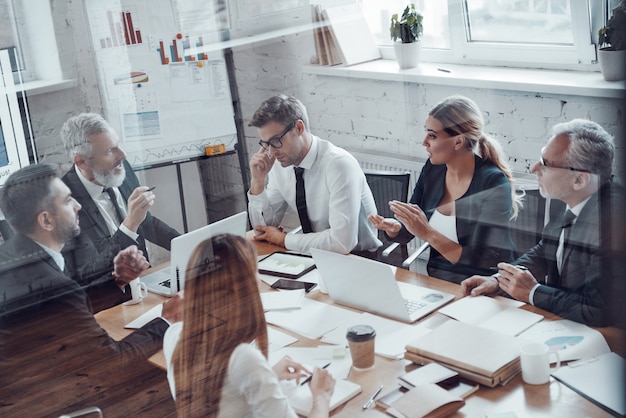 Top view of successful business team analyzing strategy while working in the modern office