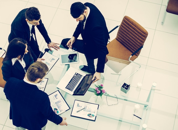 Photo top view of successful business team discussing marketing graphics before the meeting in a modern office .