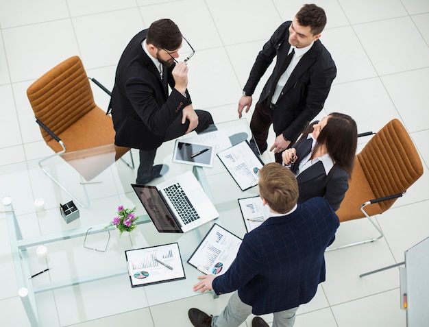 Top view of successful business team discussing marketing graphics at the workshop meeting in a modern office .the photo has a empty space for your text.