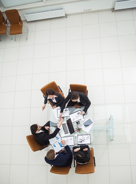 Vista dall'alto del team aziendale di successo che discute schemi di marketing e programmi finanziari per lo sviluppo dell'azienda. la foto è uno spazio vuoto per il testo