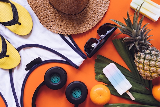 Top view of Summer accessories on orange background