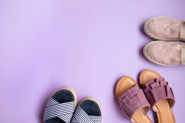 Top view of summer shoes on lilac