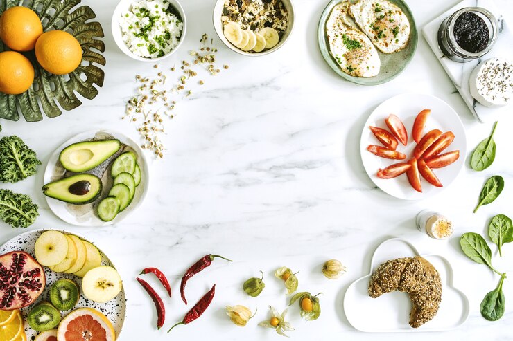 The top view of super food on the white marble table. Flat lay. Variuos vegetables ingredients and healthy food for vegetarians. Breakfast table. Copy space. Template.