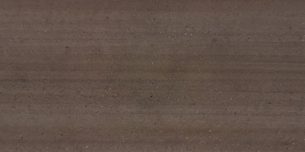 Top view of surface of gravel road made of small stones and sand with traces of car tires