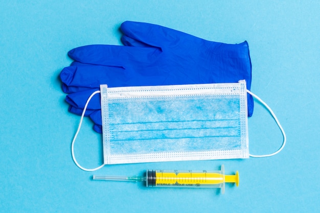 Top view of surgical gloves, a face mask, and syringe