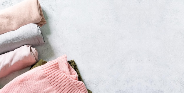 Top view of sweaterlilac knitted sweater and blue jeans lie on\
white background overhead view