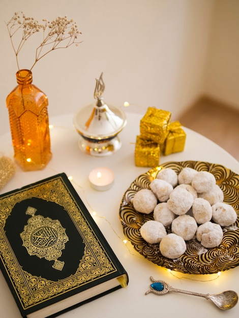 Top view table arrangement with quran, pastries and tea