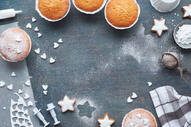 설탕을 뿌린 머핀 및 크리스마스 스타 쿠키가있는 테이블의 상위 뷰