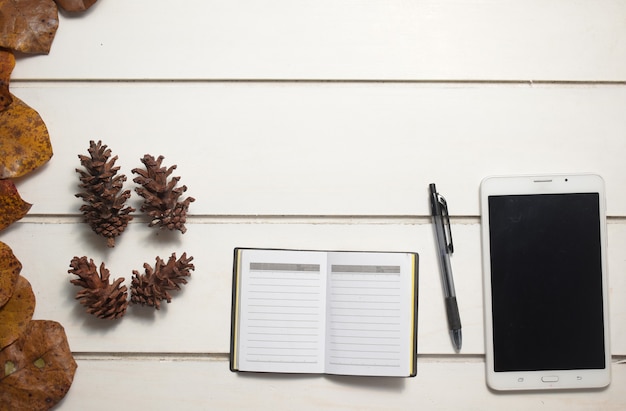 Top view of Tablet and note book with pen on white table background, flat lay design