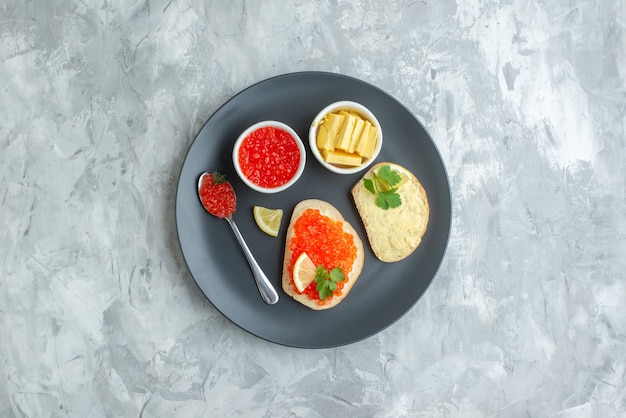 Vista dall'alto gustosi panini al caviale all'interno della piastra con formaggio sulla superficie bianca snack cena cibo per pesci piatto pane toast colazione