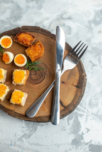 top view tasty caviar sandwiches with boiled eggs and cutlery on wooden board white surface food breakfast seafood fish toast meal