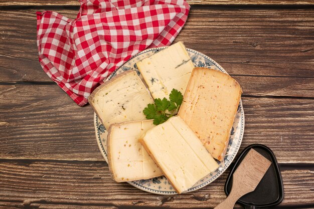 Top view of tasty cheese platter on a wooden table