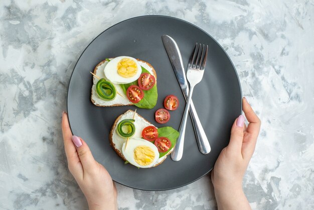 접시에 나이프와 포크를 넣은 상위 뷰 맛있는 계란 샌드위치 흰색 배경 샌드위치 다이어트 점심 토스트 음식 건강 버거 빵 식사