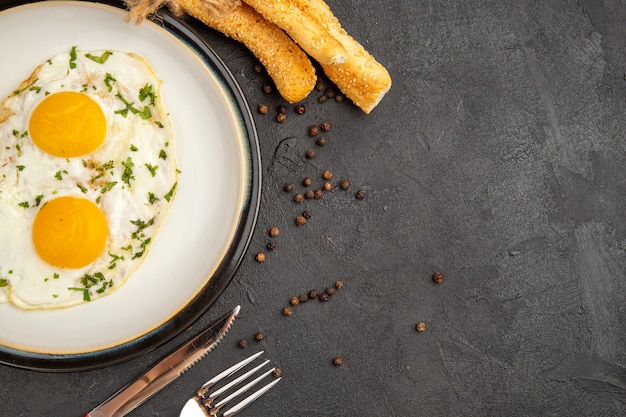 top view tasty omelette with fork and knife on dark background bread lunch egg boil meal breakfast omelette food