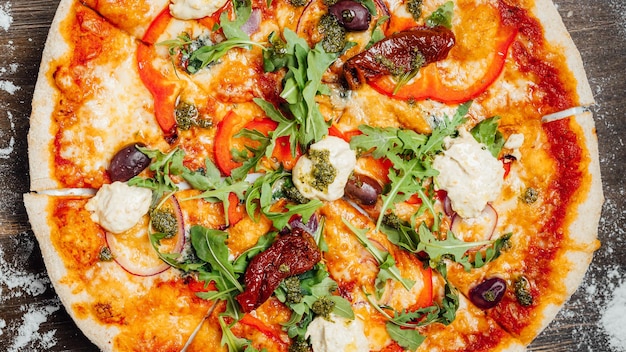 Top view of a tasty pizza with vegetables and greens