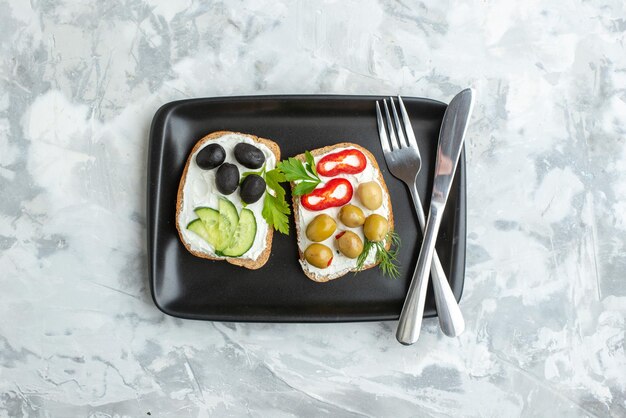 Top view tasty sandwiches with cucumbers and olives on white surface