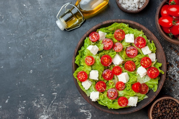 Top view tasty vegetable salad with sliced cheese tomatoes and seasonings on dark background lunch health diet meal food color