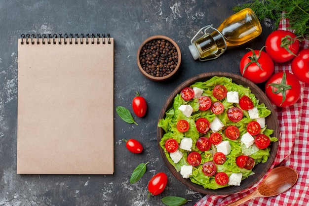 Top view tasty vegetable salad with sliced cheese tomatoes and seasonings on a dark background meal food color diet lunch health