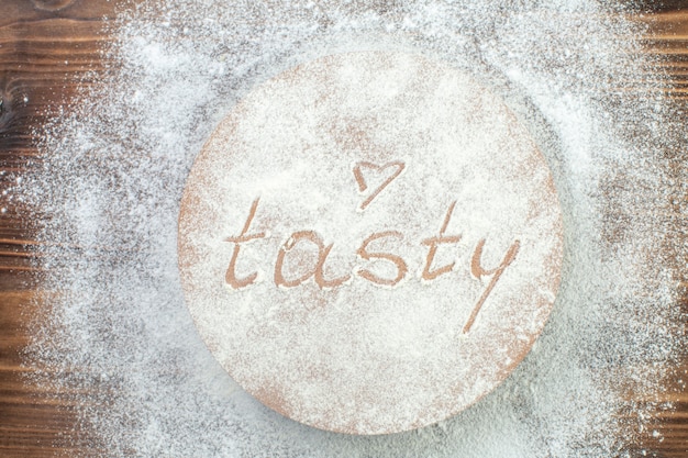 top view tasty writing around flour on brown table