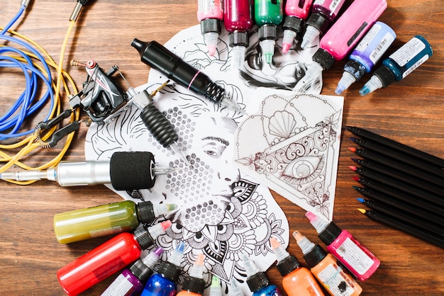 Top view of tattoo equipment details on a wooden background