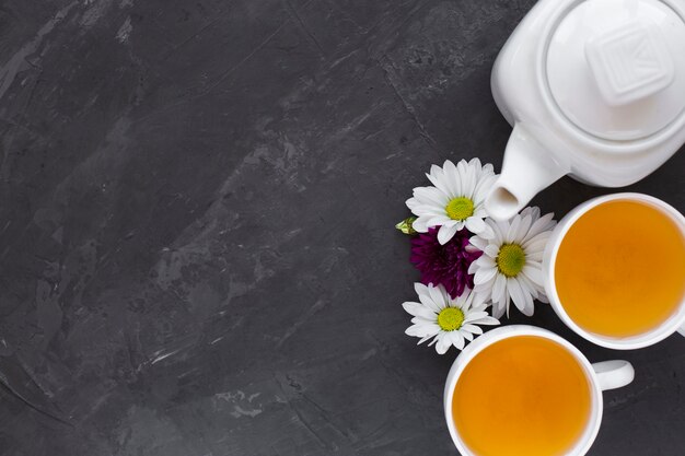 Top view tea cups and flowers with copy space