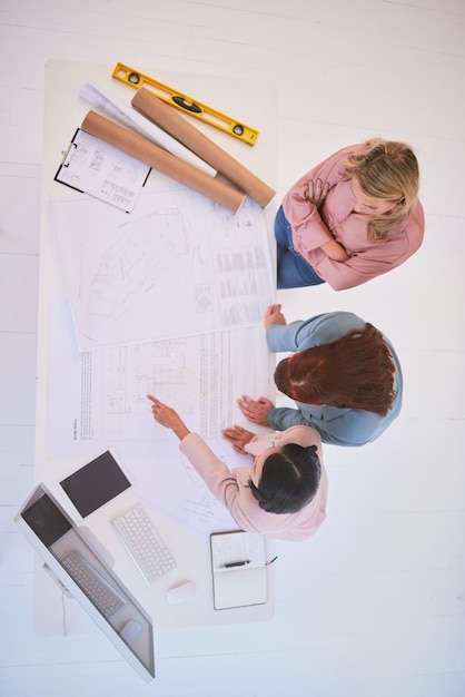 上からの建設プロジェクトのためのオフィスの青写真を持つ平面図のチームワークと建築家建築設計スケッチを使用した請負業者またはエンジニアの建築および開発計画の会議