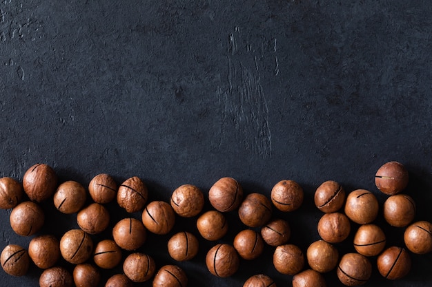 Photo top view of texture of fresh natural unshelled raw macadamia nuts