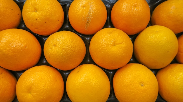 Фото Топ вид текстуры свежих апельсинов положить в поле готовы к продаже на супер рынке, фон